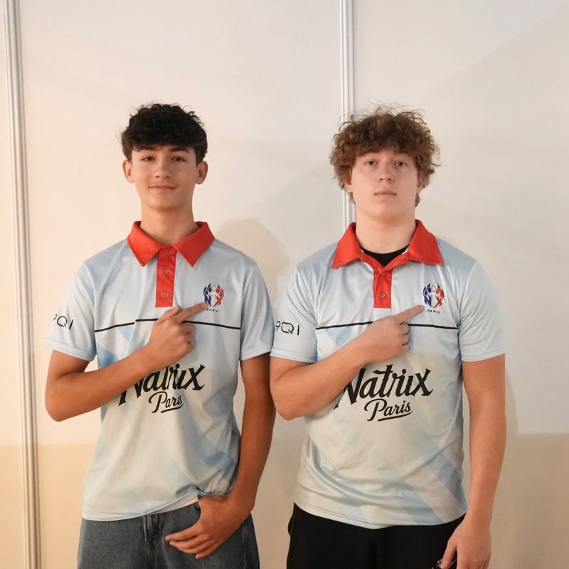 Two players wearing the Natrix Paris polo, pointing at the Paris EWC crest on the chest